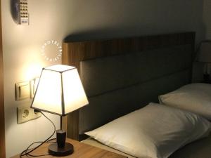 lampa siedząca na stole obok łóżka w obiekcie Aleon Hotel w mieście Tbilisi City