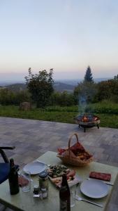 a table with plates of food and a fire pit at Ferienbungalow Sonnenwald Bayerischer Wald in Schöfweg