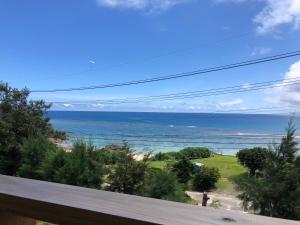 uma vista para o oceano a partir de uma varanda em Guest room Halemakana em Amami