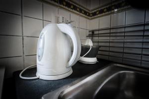 a white mixer sitting on a counter next to a sink at La Casa del Fotografo in Mortelle