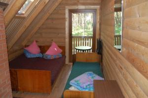 Habitación pequeña con 2 camas en una cabaña de madera en Edmundas, en Palanga