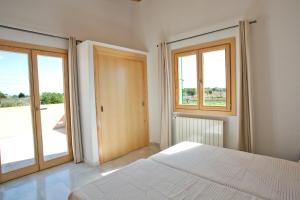 ポルト・クリストにあるFinca Sa Carrotjaのベッドルーム1室(白いベッド1台、窓2つ付)