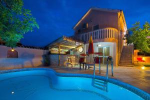 a villa with a swimming pool at night at Apartmani Mihailovic in Budva