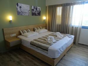 a bedroom with a large bed with towels on it at Horizon Beach Hotel in Plakias