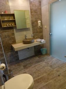 a bathroom with a sink and a toilet at Horizon Beach Hotel in Plakias