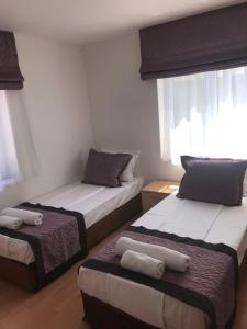 a room with two beds and a window at Aurora Guest House in Golden Sands