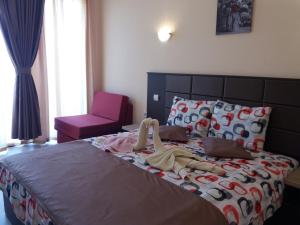 a bedroom with a bed with a doll on it at Hotel Sirena in Primorsko