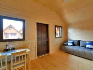 a room with a couch and a table and a window at Domki Korsarz Gaski in Gąski