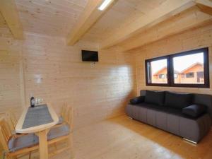 a living room with a couch and a table and a window at Domki Korsarz Gaski in Gąski