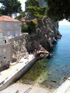 eine Gruppe von Menschen, die auf einer Klippe im Wasser schwimmen in der Unterkunft Old Harbour City Center Apartment in Dubrovnik