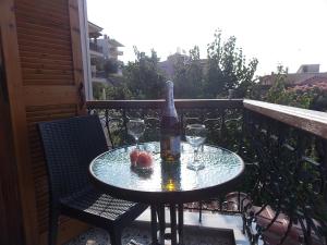 a table with a bottle of wine and glasses on a balcony at Studios Kentia in Skala Marion