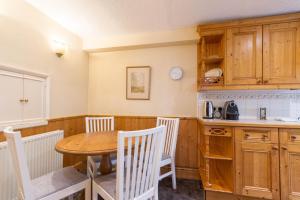 a kitchen with a wooden table and chairs and a table at UNIQUE COUNTRY COTTAGE Nr NATURE RESERVE Sleeps 4 in London