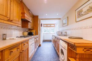 a large kitchen with wooden cabinets and white appliances at UNIQUE COUNTRY COTTAGE Nr NATURE RESERVE Sleeps 4 in London