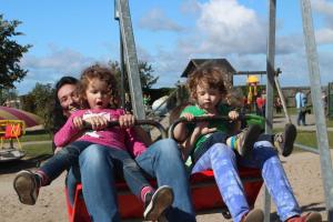 a man and two little girls riding on a swing at Haus Feldmann in Ranzow