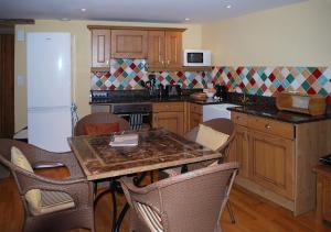 une cuisine avec une table et des chaises dans l'établissement Val Rive - Rose Cottage, à Dinan