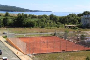 a tennis court in a field next to the water at Guest House ASK in Primorsko