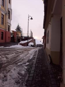 an empty street with snow on the ground at Traditional Hermannstadt in Sibiu