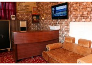 a waiting room with a flat screen tv on a stone wall at Inderlok Hotel in Chandīgarh