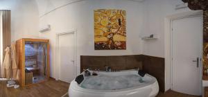 a bathroom with a bath tub with a painting on the wall at Palermo Gallery in Palermo +108 photos
