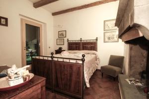 um quarto com uma cama, uma cadeira e um lavatório em Il Vecchio Comune em Santa Sofia