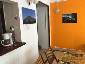 a table and chairs in a room with an orange wall at L'Escale du Mouillage in Saint-Pierre