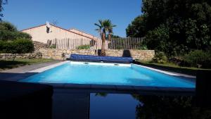 una piscina en un patio con una valla y árboles en chez cathie, en Draguignan