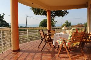 a patio with a table and chairs on a porch at Village Guesthouse in Keramoti