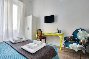 ローマにあるA+ Bed and Breakfastのベッドルーム(ベッド1台、椅子、テレビ付)