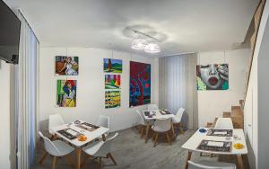 a restaurant with tables and chairs and paintings on the walls at Palermo Gallery in Palermo