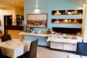 a dining room with a table with plates of food at Villa Porto in Pobierowo