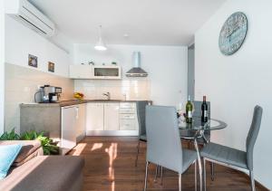 a kitchen and living room with a table and chairs at City market apartments Pula in Pula