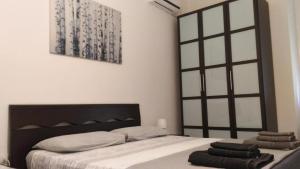 a bedroom with a bed with a black headboard at B&B 55 Alghero in Alghero