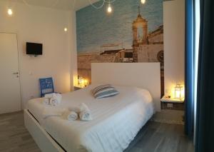 a bedroom with a large white bed with towels on it at Lyria in Marzamemi