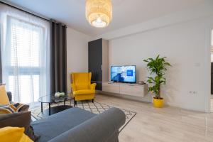 ein Wohnzimmer mit einem blauen Sofa und einem gelben Stuhl in der Unterkunft Old town apartment Maritta in Zadar