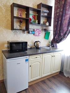 a small kitchen with a sink and a microwave at Gorsad Apartment in Odesa