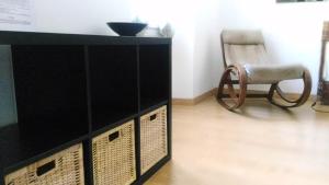 a black cabinet and a chair in a room at B&B 55 Alghero in Alghero