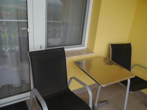 a table and chairs in a room with a window at Hévíz Erika Apartman in Hévíz