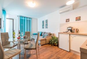 cocina y sala de estar con mesa y sofá en City market apartments Pula, en Pula