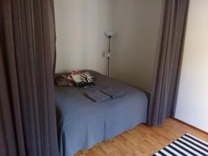 Cozy studio in Helsinki City Center في هلسنكي: سرير صغير في زاوية غرفة مع ستائر