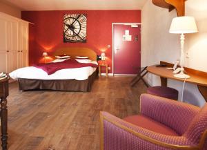ein Hotelzimmer mit einem Bett und einem Schreibtisch in der Unterkunft Logis Hôtel-Restaurant Le Relais in Hauterives