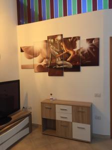 salon z pięcioma obrazami na ścianie w obiekcie casasuisassi w mieście Matera