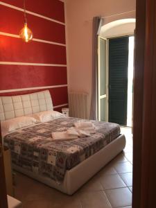 sypialnia z łóżkiem z czerwoną ścianą w obiekcie casasuisassi w mieście Matera +5 zdjęć
