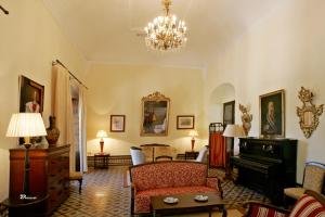 a living room with a couch and a piano at Posada de Palacio in Sanlúcar de Barrameda