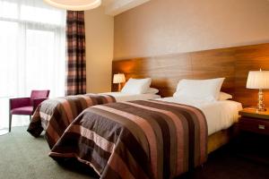 um quarto de hotel com duas camas e uma janela em Moyvalley Hotel & Golf Resort em Moyvally