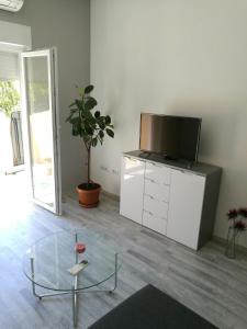 ein Wohnzimmer mit einem TV und einem Glastisch in der Unterkunft Apartman IVANKOVIC*** in Pula