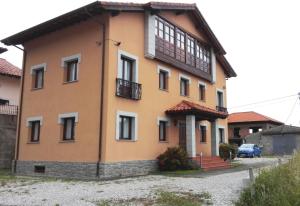 a house with a balcony on the side of it at Apartamentos Las Rosas in Cue