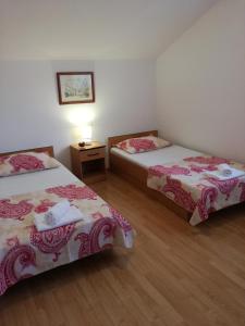 una camera con due letti e un tavolo con una lampada di Oaza a Dubrovnik