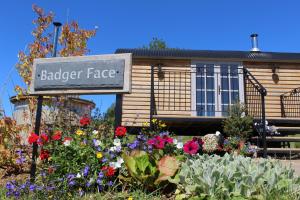 un cartel frente a un jardín con flores en Fair Farm Hideaway, en Waltham on the Wolds