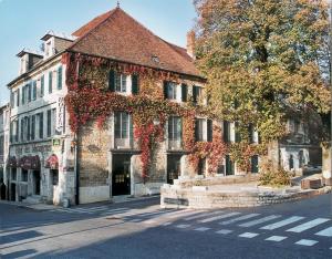 an old building on the side of a street at Logis Hôtel des Messageries in Arbois