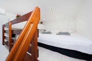 Schlafzimmer mit einem Bett mit weißer Bettwäsche und einer Leiter in der Unterkunft Dietla 99 - Studio by Homeprime in Krakau
